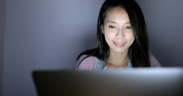 Woman working on laptop computer at night 