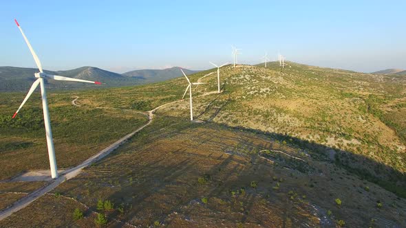 Aerial view of windmills with rotating blades on a sunny day