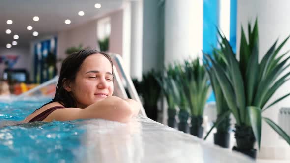 Young Attractive Woman Relaxing in the Pool Beauty Therapy and Body Care