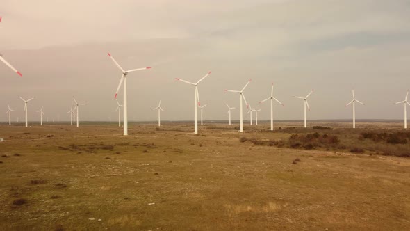 Aerial View of Wind Turbines and Agriculture Field Near the Sea at Sunset