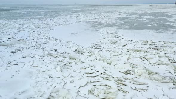 Drone Footage of Ice Shoves on Lake That Is Freezing and Thawing to Create Cracked Iceburgs on Surfa