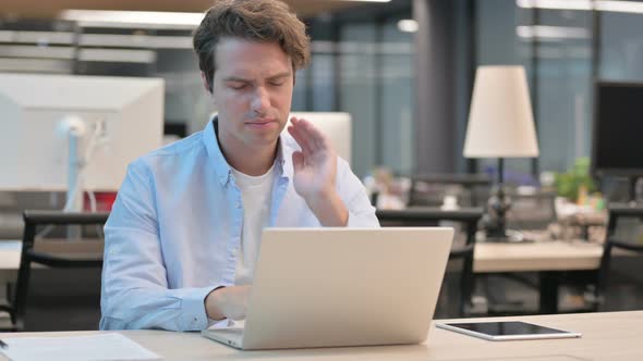 Man Having Neck Pain While Using Laptop in Office