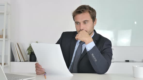 Businessman Reading Documents in Office