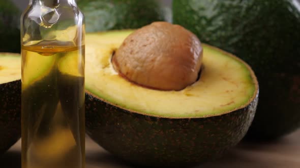 Avocado oil with avocado fruit on wooden table. Avocado is a highly nutritious fruit.