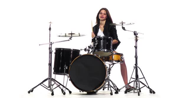 Drummer Girl Starts Playing Energetic Music, She Smiles. White Background. Slow Motion