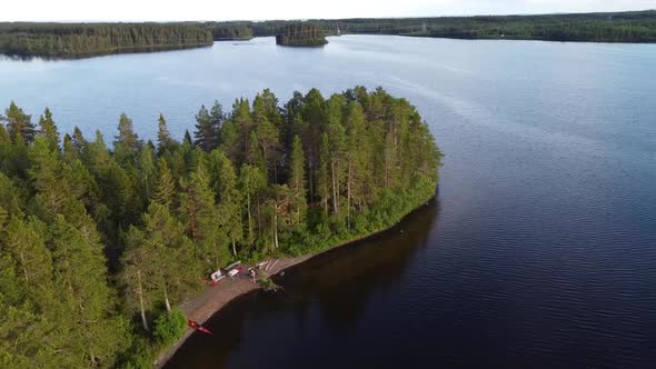 Drone Shot (rotating) of an Island in the Middle of a Northern Lake with a Kayak on the Shore