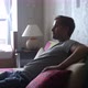 Handsome Young Man at Home Sitting on a Couch Watches TV - VideoHive Item for Sale