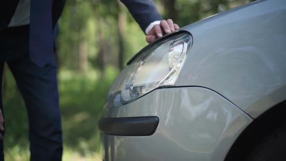 Male Caucasian Hand Touching Headlight Fixing Car Lights