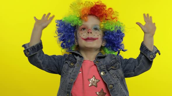 Little Child Girl Clown in Colorful Wig Making Silly Faces. Having Fun, Smiling, Dancing. Halloween