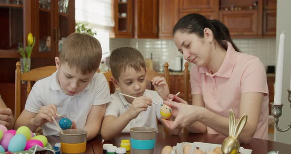 Mother and Her Two Sons Paint Easter Eggs