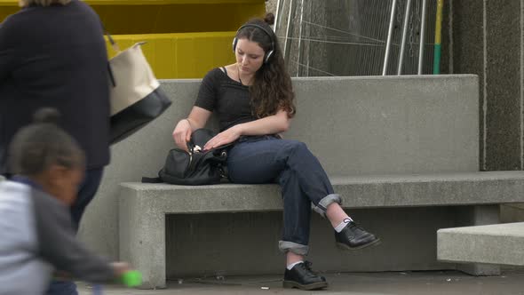 Girl sitting on a stone bench