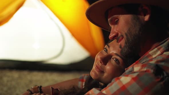 Man Hugging Woman in Front of the Bonfire on Beach Party in the Dark