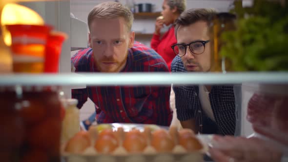 View Inside Fridge of Two Guys Taking Sausages and Sauce From Refrigerator