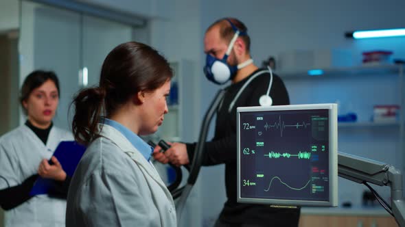 Muscular Athlete with Mask Running on Cross Trainer in Medical Laboratory