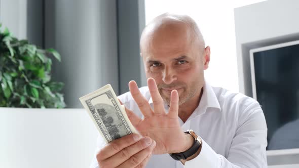 Young Successful Businessman Holding a Pack of Dollars in His Hands