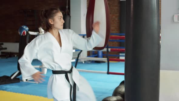 Female Kickboxer Practicing Kicks in Gym