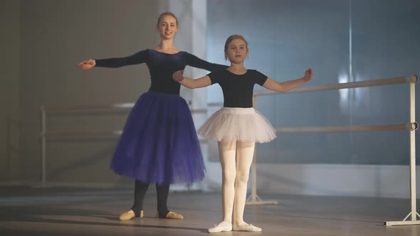 Motivated Girl and Confident Woman Doing Tendu Movement in Ballet Studio Indoors
