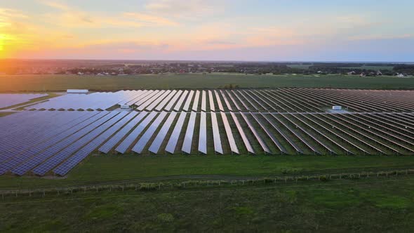 Aerial Drone View Into Large Solar Panels at a Solar Farm at Cloudy Summer Evening