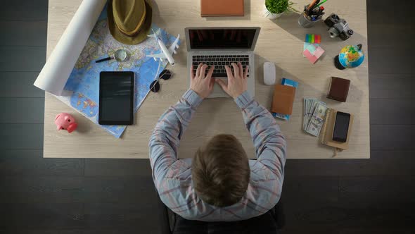 Man Visiting Web Site of Travel Agency to See Offered Tours, Planning Vacation