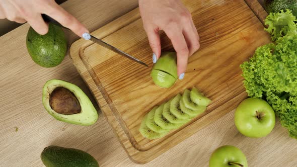 Womans Cutting Fresh Green Kiwi