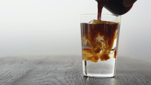 Slow Motion Making Espresso Tonic in Tumbler Glass Pour Espresso in Tonic with Ice Cube