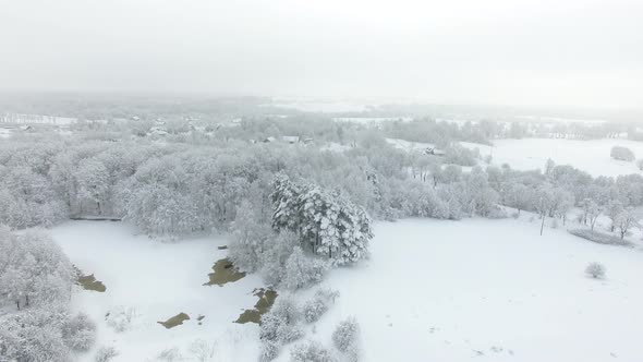 Aerial: Snow-covered countryside in deep winter