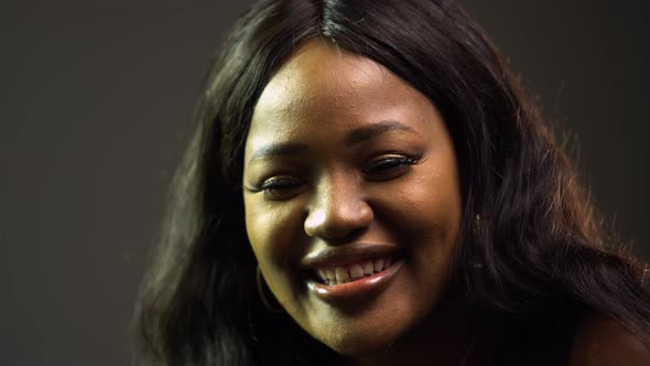 Cute Smiling African American Woman Enjoying Music Over Gray Background