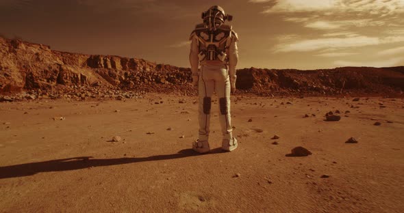 Anonymous Astronauts Standing on Arid Terrain of Mars