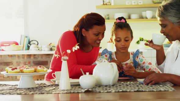 Happy multi-generation family having tea in dining table 4k