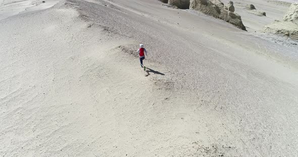 Aerial footage of woman trail runner cross country running  on sand desert dunes