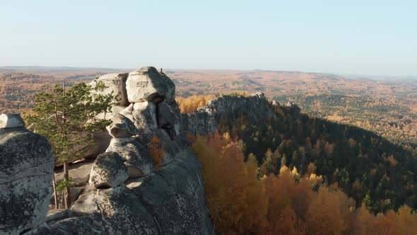 Aerial View of a Cliff Surrounded By a Colorful Autumn Forest at Sunset