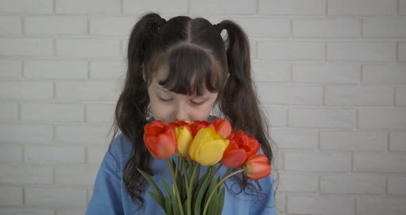 Child with spring bouquet of tulips. 