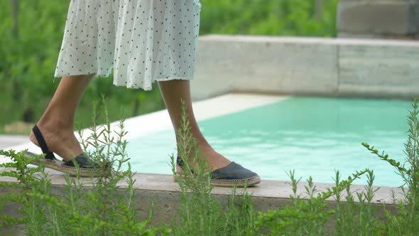 Closeup of woman walking in dress, feet and sandals traveling at a luxury resort in Italy, Europe.