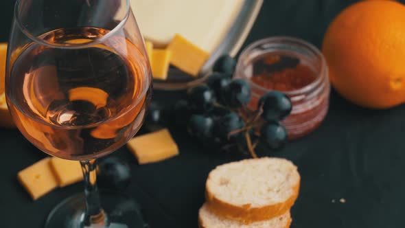 A Glass of Rose Wine Swirls With Appetizers