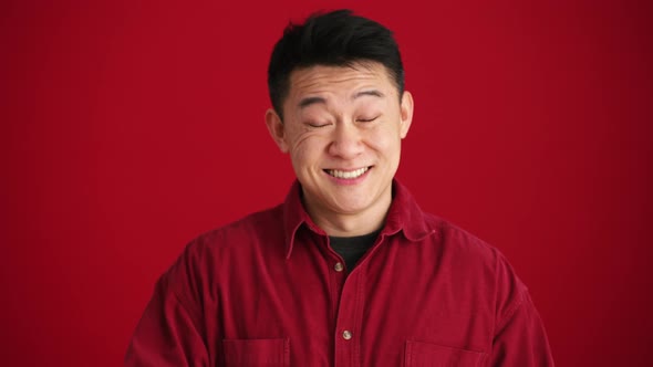 Smiling Asian man wearing shirt showing thumb up gesture