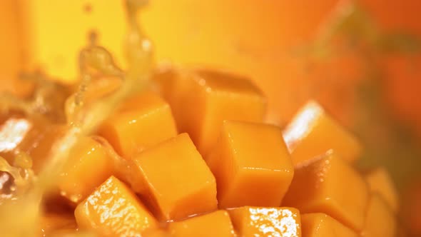 Slow Motion Shot of Mango Juice Splashing Through Mango Cube Slices