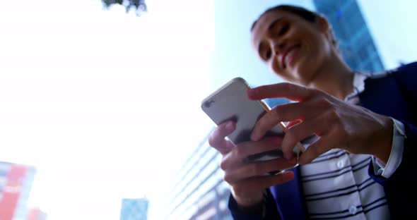 Businesswoman text messaging on mobile phone