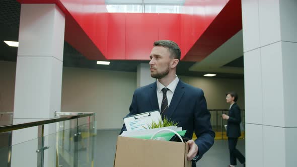 Slow Motion of Unhappy Young Man Leaving Work with Box of Things After Dismissal