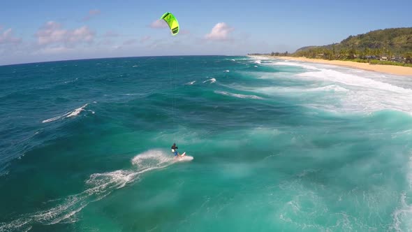 Aerial view of a man kitesurfing in Hawaii.