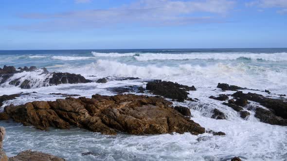 Rough ocean waves breaking onto rocky coastline in South Africa.