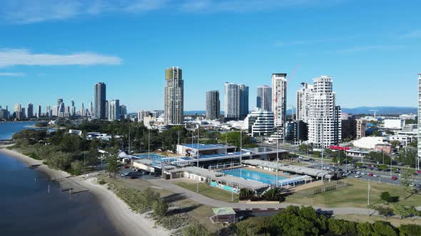 Creative drone view of a inner city Aquatic Centre on a coastal strip with a towering skyline backdr