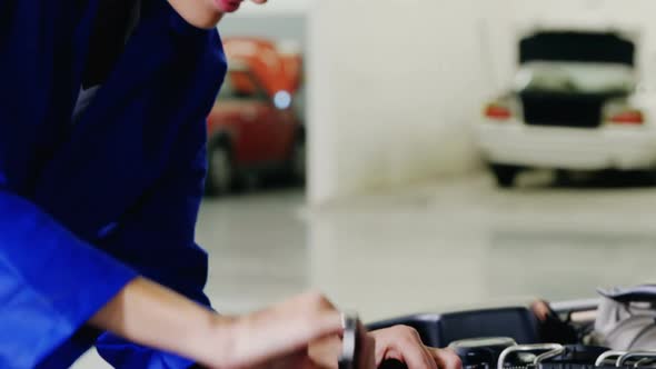 Female mechanic servicing a car