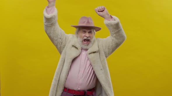 Stylish Old Man In Pink Clothes On Yellow Background