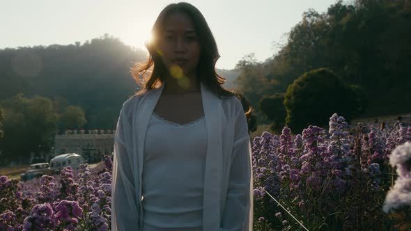 Young Asian Woman Walking in Flower Field on Sunset