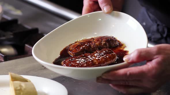 Showing seared foie gras on sherry wine and Pedro Ximenez sauce to camera