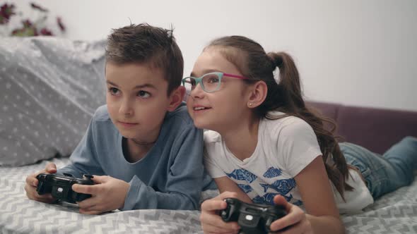 Happy Kids Playing Video Game with Joystick at Home. Friends Play Game Console