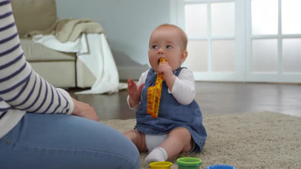 Teething Baby Girl Nibbling At Toy