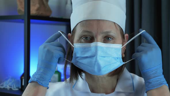 Sad and tired medical doctor scientist taking off protective medical face mask after long shift