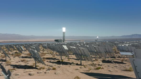 Amazing Sunset Aerial View of Solar Tower and Panels Stand in a Row in Fields