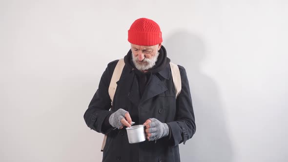 Portrait of Homeless Beggar with Cup for Money Finds Large Bill in His Cup